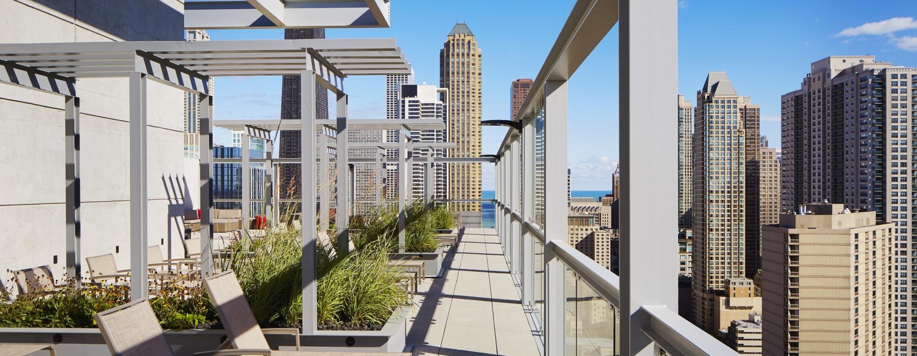 a walkway with chairs and tables on it and buildings in the background