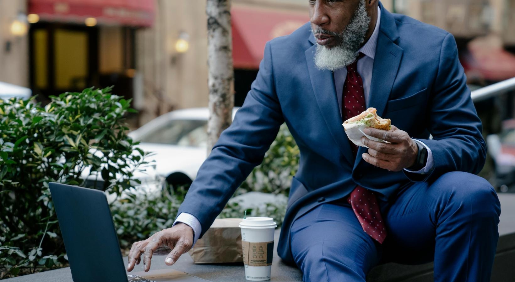 The essence of exceptional living a person sitting at a table with a laptop and a cup of coffee